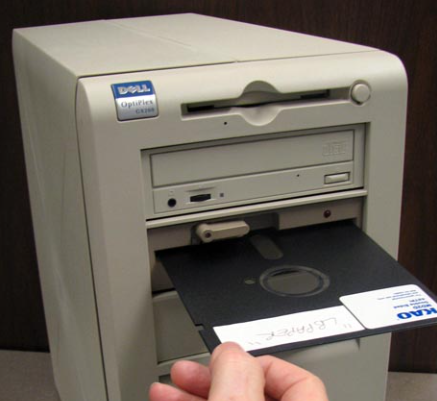 5.25 inch floppy disk being loaded into an ancient PC